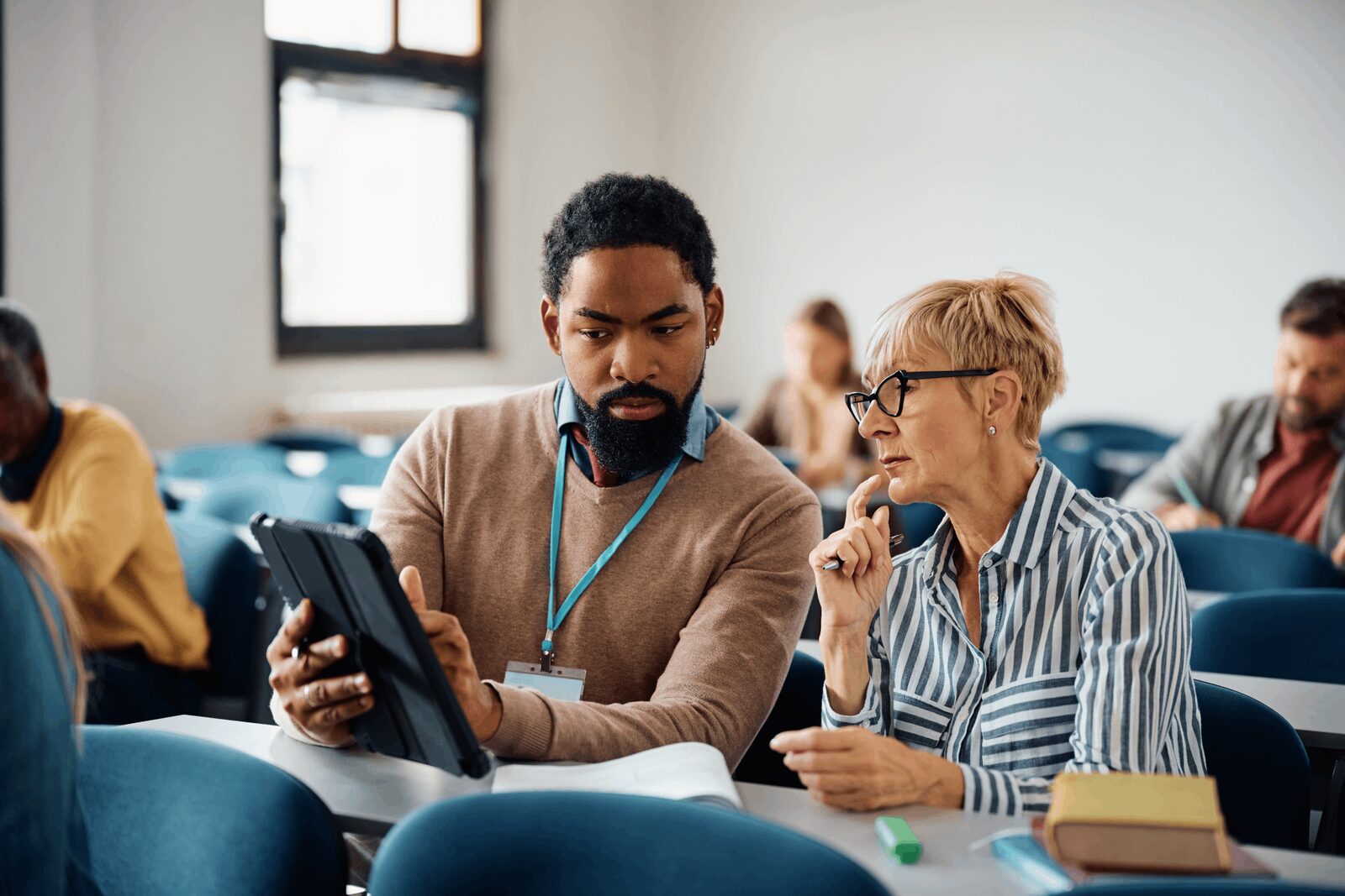 Two professionals talking during a training session in a lecture room