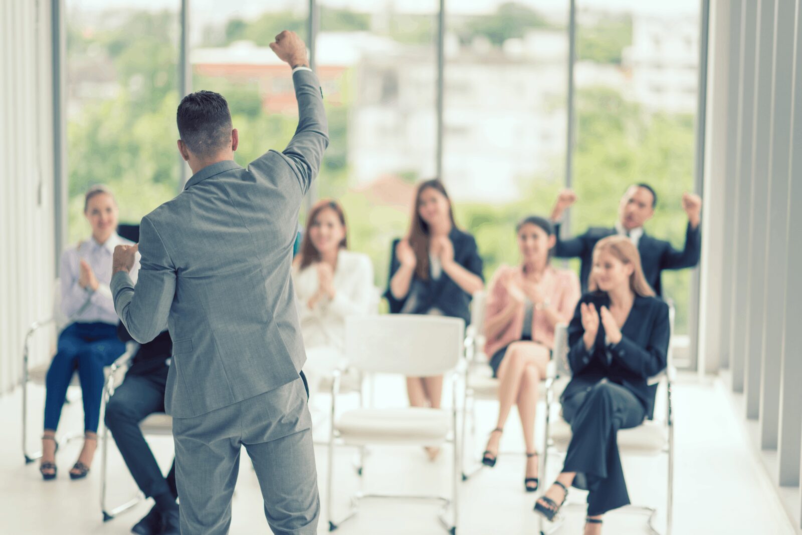 Presenter addressing a seated audience of professionals in a bright room
