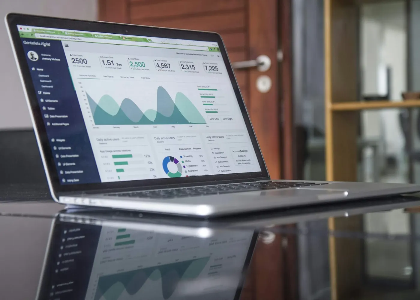 A laptop screen shows a data dashboard with analytics charts for vet compliance.