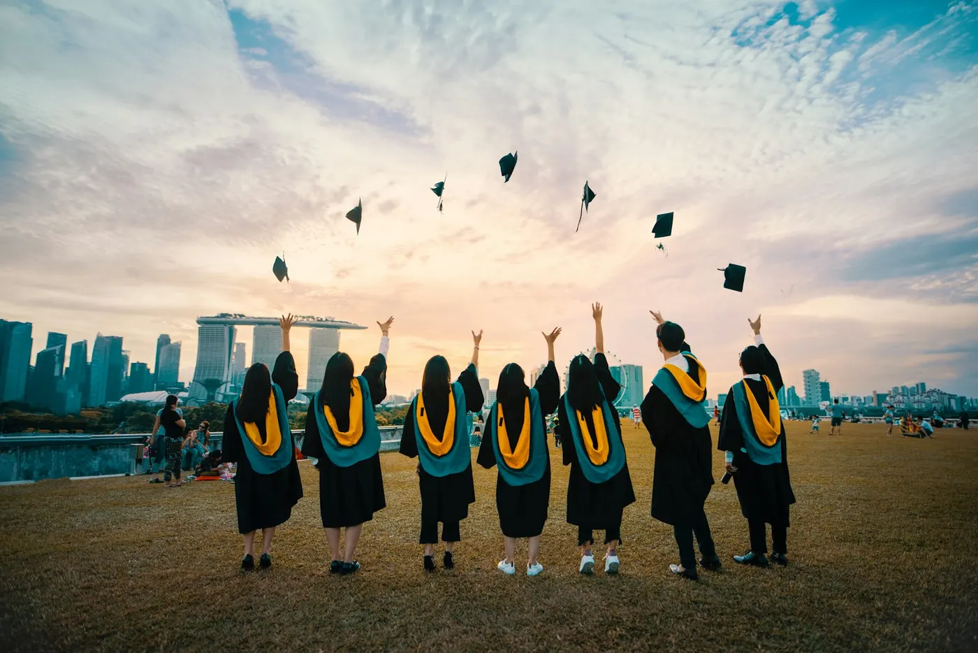 Graduates celebrate their achievement throwing caps in the air, representing successful vocational education training.