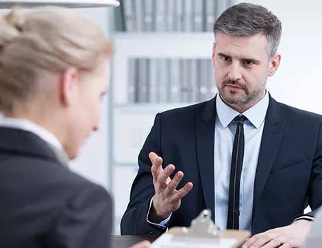A man interviews a woman during a vet compliance assessment, demonstrating professional training practices.